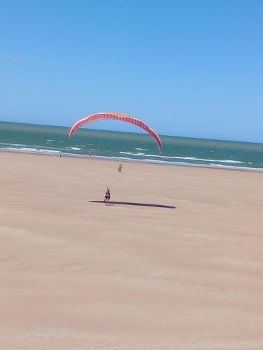 a person is flying a kite on the beach at Rancho aparte duplex in San Clemente del Tuyú