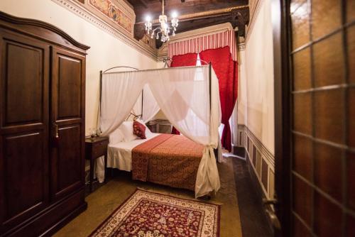 a bedroom with a bed with a canopy at All'ombra della Torre only Rooms in Siena