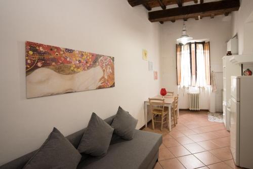 a living room with a couch and a painting on the wall at All'ombra della Torre only Rooms in Siena
