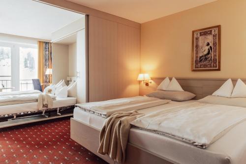 a hotel room with two beds and a window at Hotel Römerhof Superior in Obertauern
