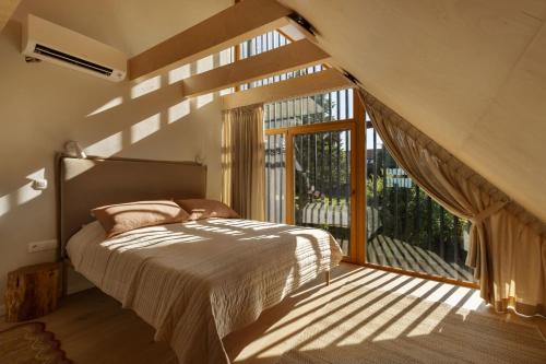 a bedroom with a bed and a large window at Dymnica 5 in Ulinia