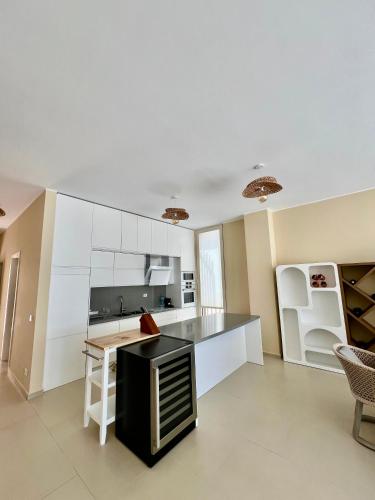 a kitchen with white cabinets and a black counter top at Elite Vila with Pool, Green Coast in Palasë