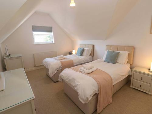 a attic bedroom with two beds and a window at Meridian in St Ives