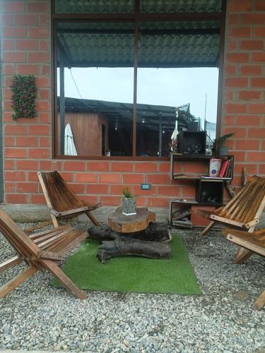 a patio with two chairs and a table with a cat laying on the grass at Villa Chica in Archidona