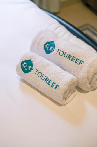 two towels with the word volunteer written on them on a bed at Beit Toureef - RESIDENCES in Beirut