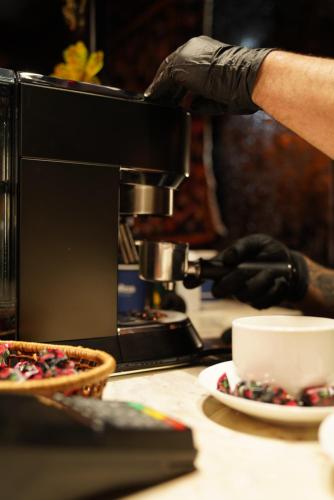 a person is making a cup of coffee on aounter at Hotel Hobbiton near Vardzia Caves in T'mogvi