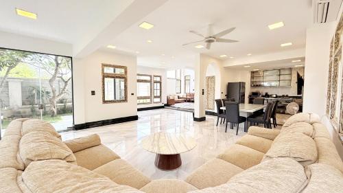 a large living room with a couch and a table at Baan Dhewaran Beachfront Villa in Na Jomtien