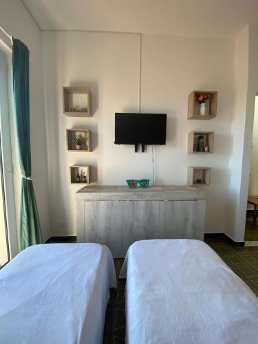 a hotel room with two beds and a flat screen tv at Casa Rebecca in San Martino