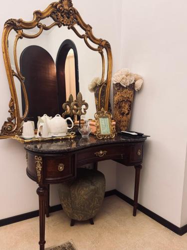 a dressing table with a mirror and a clock on it at Conacul Coroanei Luxury Boutique Hotel in Bucharest