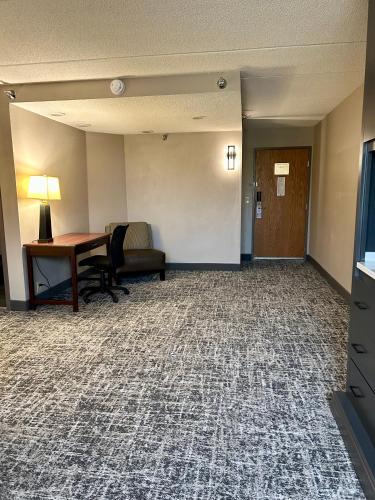 an empty hotel room with a desk and a chair at Best Western Plus Kelly Inn in Saint Cloud