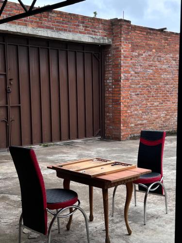 a wooden table and two chairs next to a brick wall at Hotel Egrisi in Senaki in Senaki