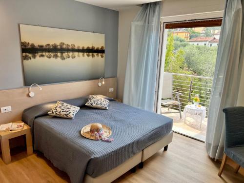 a bedroom with a bed with a baby in a basket on it at Eco Hotel Ariston in Malcesine