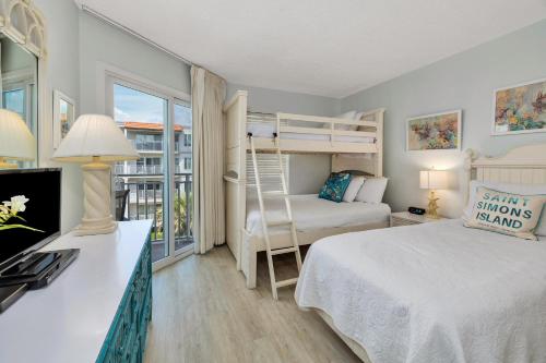 une chambre avec un lit et un lit superposé dans l'établissement Beach Club #313, à Île de Saint-Simon