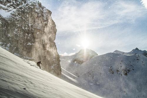 a person is skiing down a snow covered mountain at Hotel Römerhof Superior in Obertauern