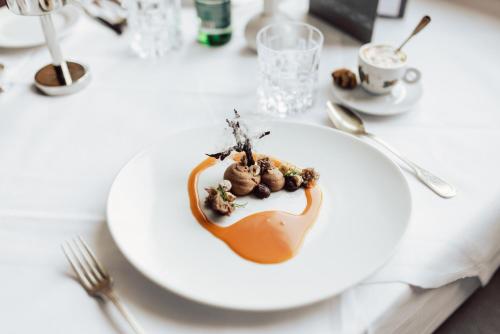 a white plate with a dessert on a table at Hotel Römerhof Superior in Obertauern