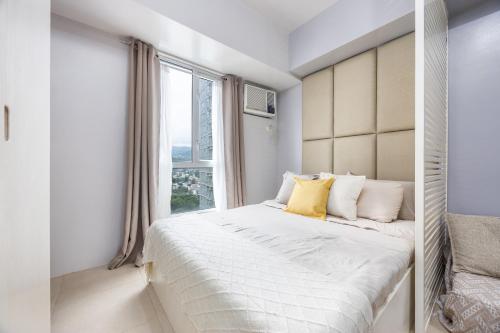 Postel nebo postele na pokoji v ubytování Virgo Nest Rentals - Avida Riala IT Park - City View