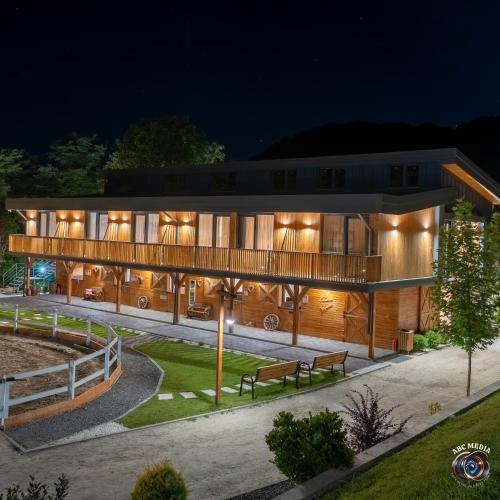 a building with a deck at night at Ecvestria Chalet in Ocnele Mari