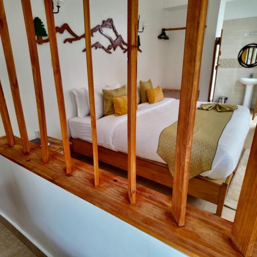 a bedroom with a white bed with wooden posts at Paradise Farm Cottages Mbui Nyeri in Ihua