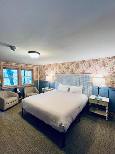a bedroom with a large white bed and a chair at Stonehurst Manor Breakfast & Dinner Included in North Conway