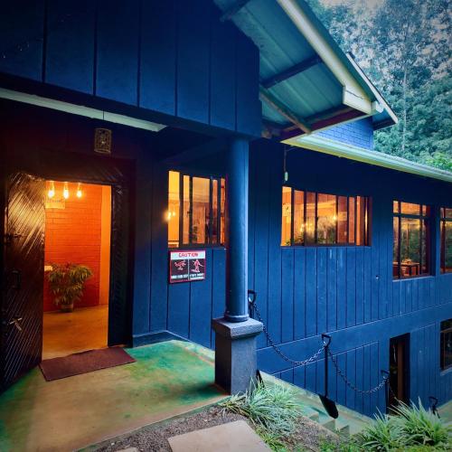 a blue house with a blue door and windows at Paradise Farm Cottages Mbui Nyeri in Ihua