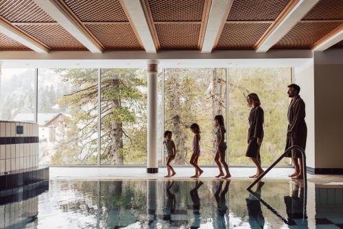 a family walking in a swimming pool at Hotel Römerhof Superior in Obertauern