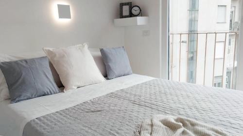 a bedroom with a white bed with pillows and a window at QuickHome La Torretta in Asti