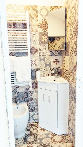 a bathroom with a white sink and a toilet at QuickHome La Torretta in Asti
