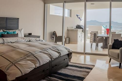 卡波圣卢卡斯Cascadas del Pedregal的一间带大床的卧室和一间餐厅