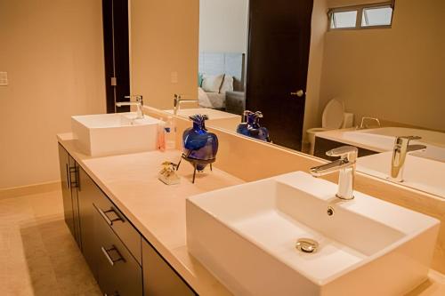 卡波圣卢卡斯Cascadas del Pedregal的配有两个水槽和一面大镜子的浴室