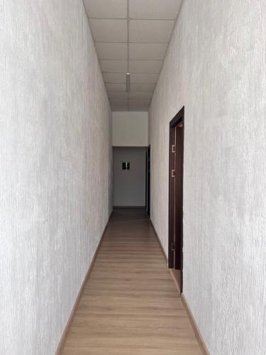 an empty hallway with a door and a wooden floor at Hotel Egrisi in Senaki in Senaki