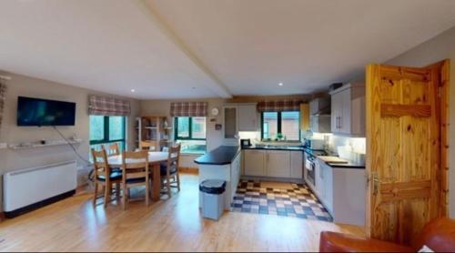 a kitchen and dining room with a table and chairs at Cois na hÉirne - Log Cabin I Lake View I Hot Tub in Belturbet