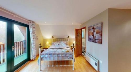 a bedroom with a bed in the corner of a room at Cois na hÉirne - Log Cabin I Lake View I Hot Tub in Belturbet