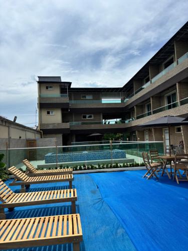 a pool with lounge chairs and a building at Hotel Nazareno Coveñas in San Antero