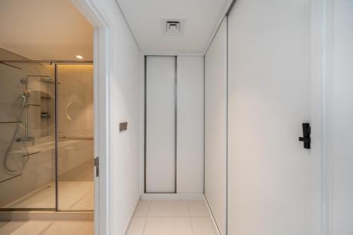 a bathroom with a shower and a glass door at Most Luxurious2br Apt Private Beach in Dubai