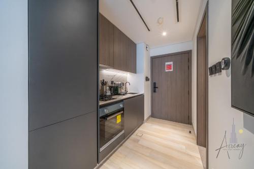 a kitchen with a stove top oven next to a door at Grove Luxurious Stu Best community Art & Design in Dubai