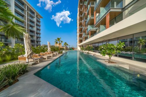 an infinity pool at the resort with chaise lounges at Grove Luxurious Stu Best community Art & Design in Dubai