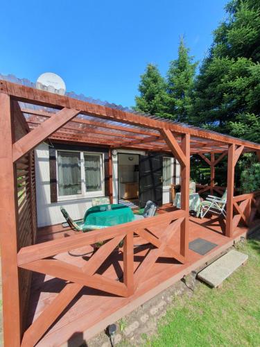 a wooden pergola on a deck next to a house at Pod orzechem in Osieki