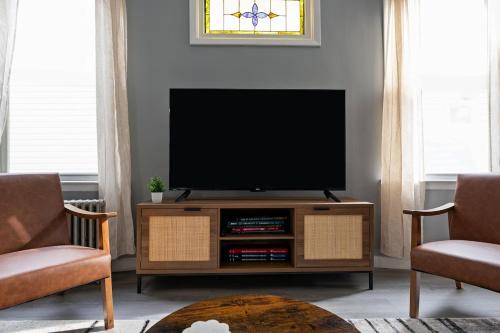 a living room with a television on a wooden entertainment center at Cozy Home, 19 min to NYC, 3 Car Driveway in Wallington