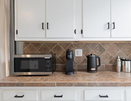 a kitchen counter with a microwave and a coffee maker at Cozy Home, 19 min to NYC, 3 Car Driveway in Wallington