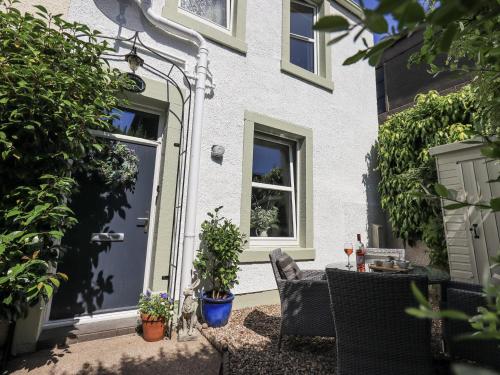 a house with a blue door and some plants at Hideaway Cottage in Penrith