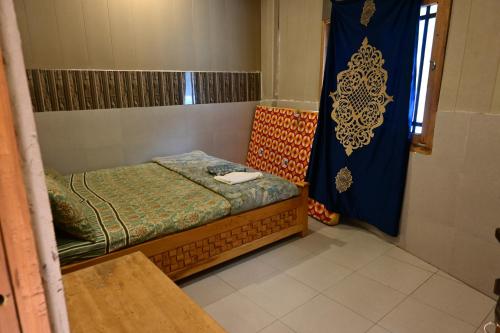 a small room with a bed and a shower at kundalshahi waterfall view hotel and resturant in Kundālshai