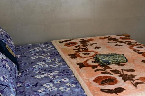 a bed with a blanket with flowers on it at kundalshahi waterfall view hotel and resturant in Kundālshai
