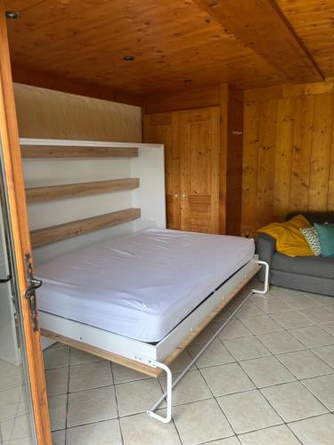 Un dormitorio con una cama en una habitación de madera. en Studio vallée de Chamonix, en Les Houches