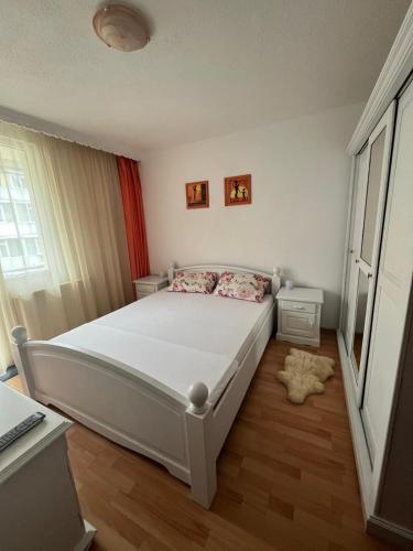 a bedroom with a white bed and a window at Central Residence in Piatra Neamţ