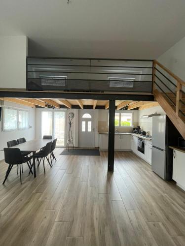 Il comprend une grande cuisine et une salle à manger avec une table et des chaises. dans l'établissement Maison neuve toute équipée, à Mervans