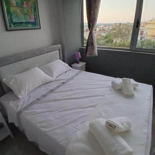 a bedroom with a white bed with towels on it at Nancy view apartment in Markopoulo