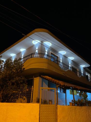 a house with a balcony with lights on it at Guesthouse SELI in Berat