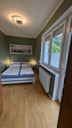 a bedroom with a bed and two windows at Dzwonki in Puck