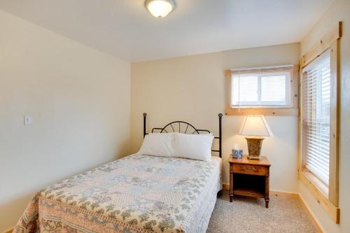 a bedroom with a bed and a table with a lamp at Fruita Vacation Rental Walk to Downtown! in Fruita