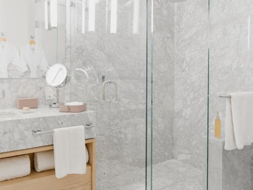 a bathroom with a shower and a sink with a mirror at Hotel Maria Camille in San Miguel de Allende